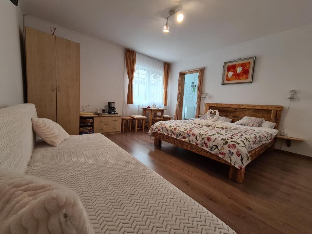 ブシュテニにあるCasa Farcaș Bușteniのベッドルーム1室(ベッド2台、ソファ付)
