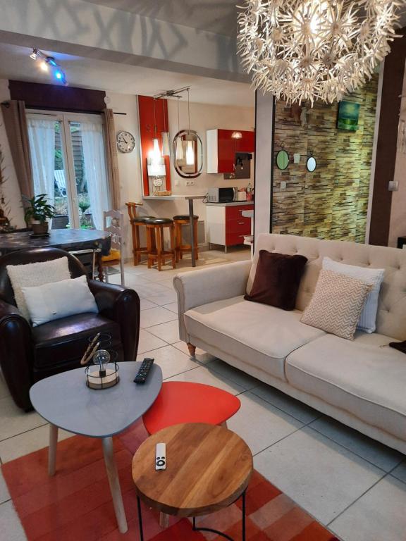 ein Wohnzimmer mit einem Sofa und einem Tisch in der Unterkunft Maison cocconing proche Reims in Boult-sur-Suippe