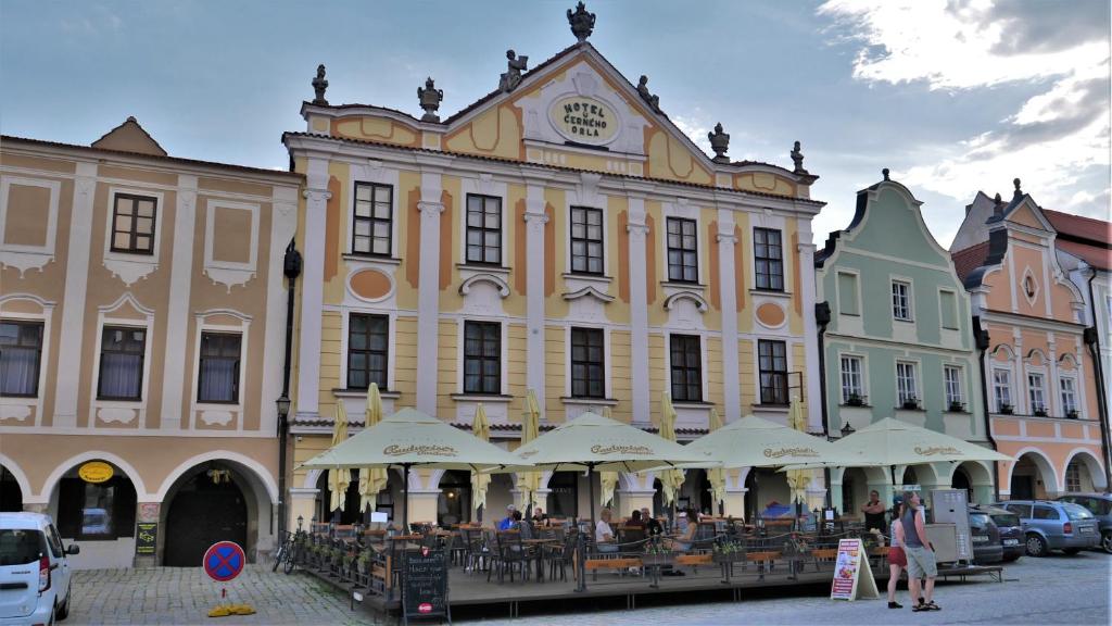 a large building with tables and chairs in front of it at Hotel U Černého orla in Telč