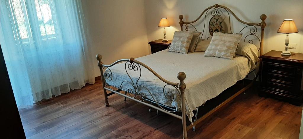 a bedroom with a bed and two night stands with lamps at Casa Al Lago in Bolsena