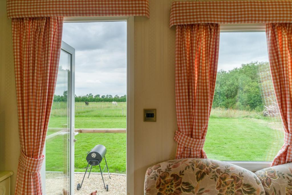 1 dormitorio con ventana y vistas a un campo en Toad Hall, Self Catering, Sleeps Four, en Southam