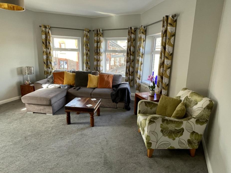 een woonkamer met een bank en 2 stoelen bij Dorchester central flat in Dorchester