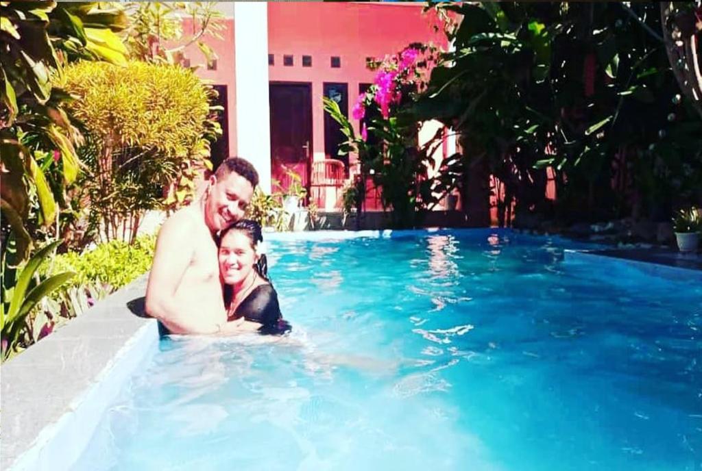 een man en een meisje in een zwembad bij Villa de Owis in Labuan Bajo