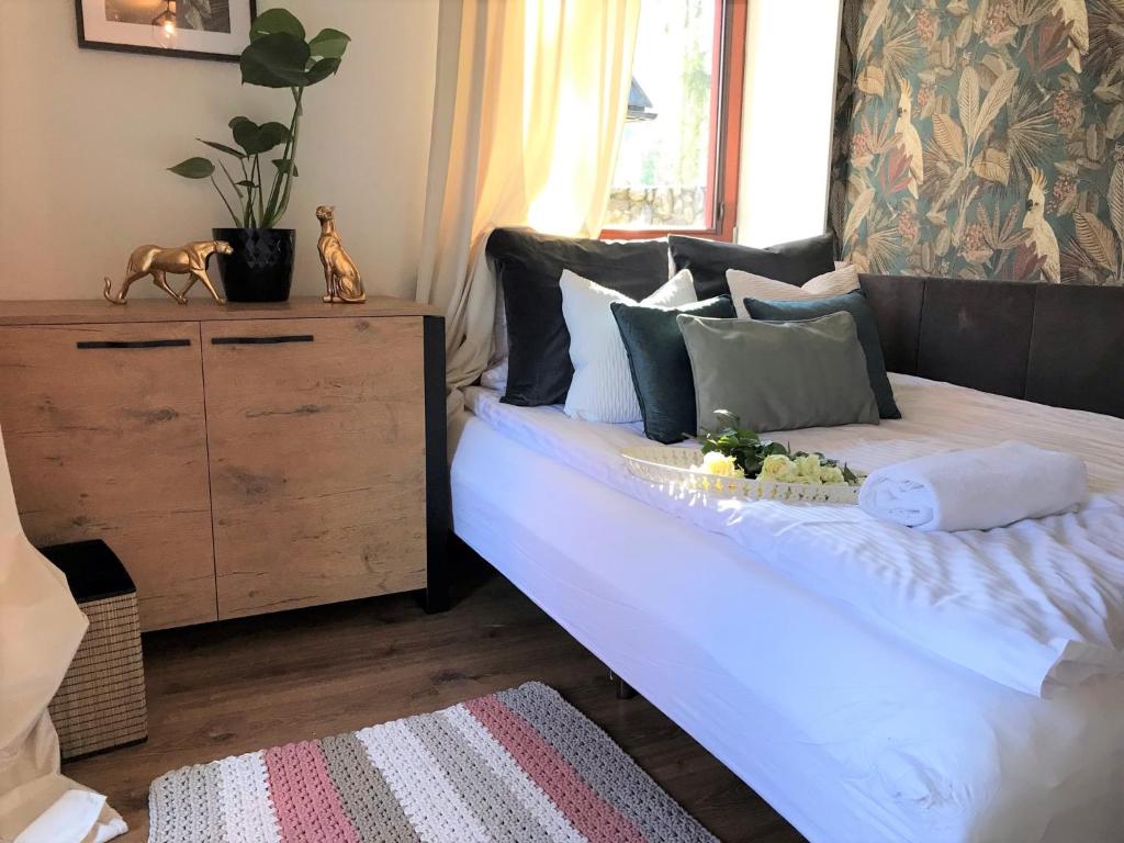 1 dormitorio con 1 cama con sábanas y almohadas blancas en Apartament Dolce Vita Kościelisko Resort, en Kościelisko