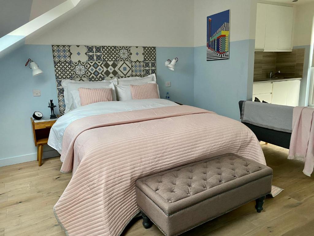 a bedroom with a large bed with a pink blanket at LUX Studio Loft in London