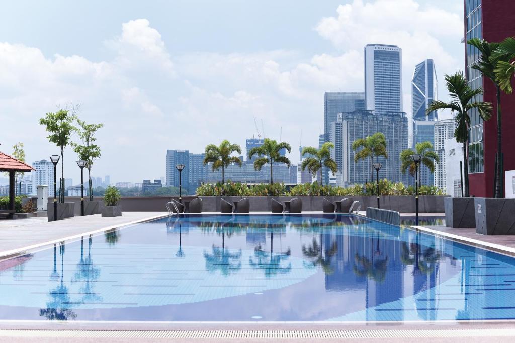 a swimming pool with a city skyline in the background at UTM Hotel & Residence in Kuala Lumpur