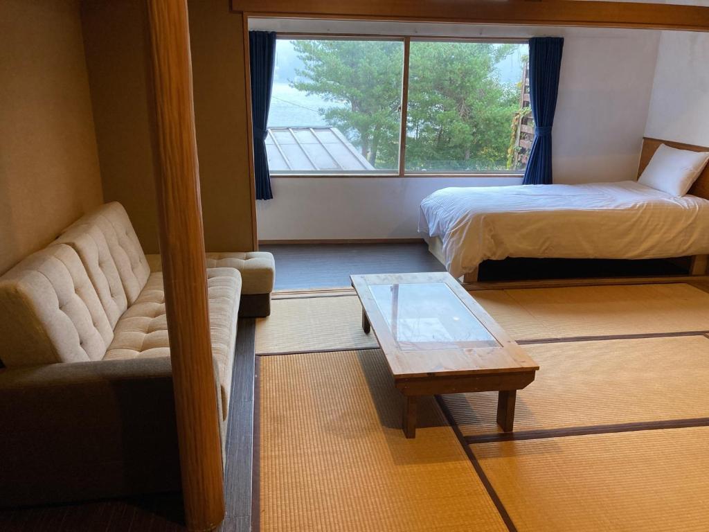 a room with two beds and a couch and a table at Koya TRIBE - Vacation STAY 81288v in Oishi
