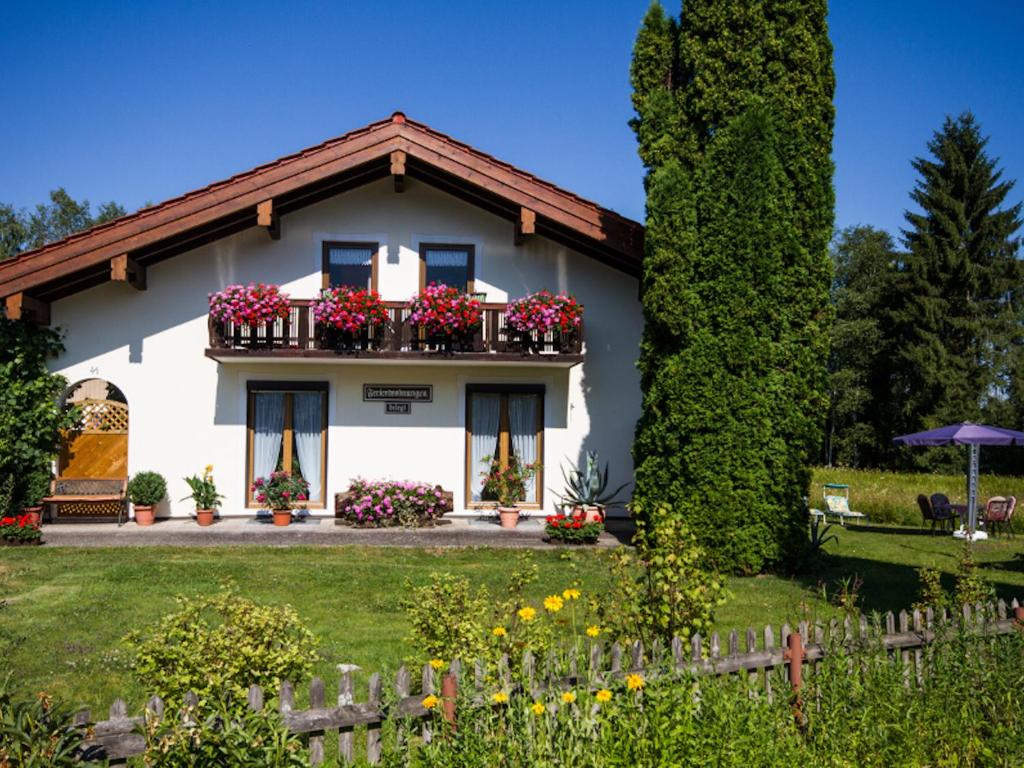 ein weißes Haus mit Blumen im Hof in der Unterkunft Haus Zimmermann - Chiemgau Karte in Inzell