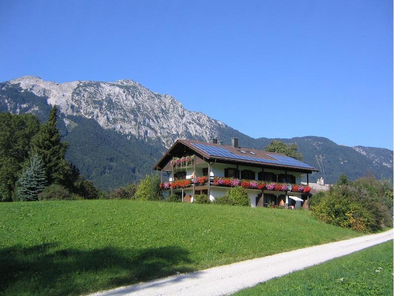 una casa con flores al lado de un campo en Landhaus Fellnerbauer, en Bad Reichenhall