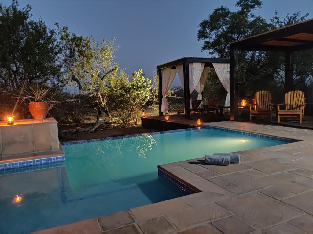 una piscina en un patio trasero con cenador en THE BAOBAB BUSH LODGE, no self catering, en Hoedspruit
