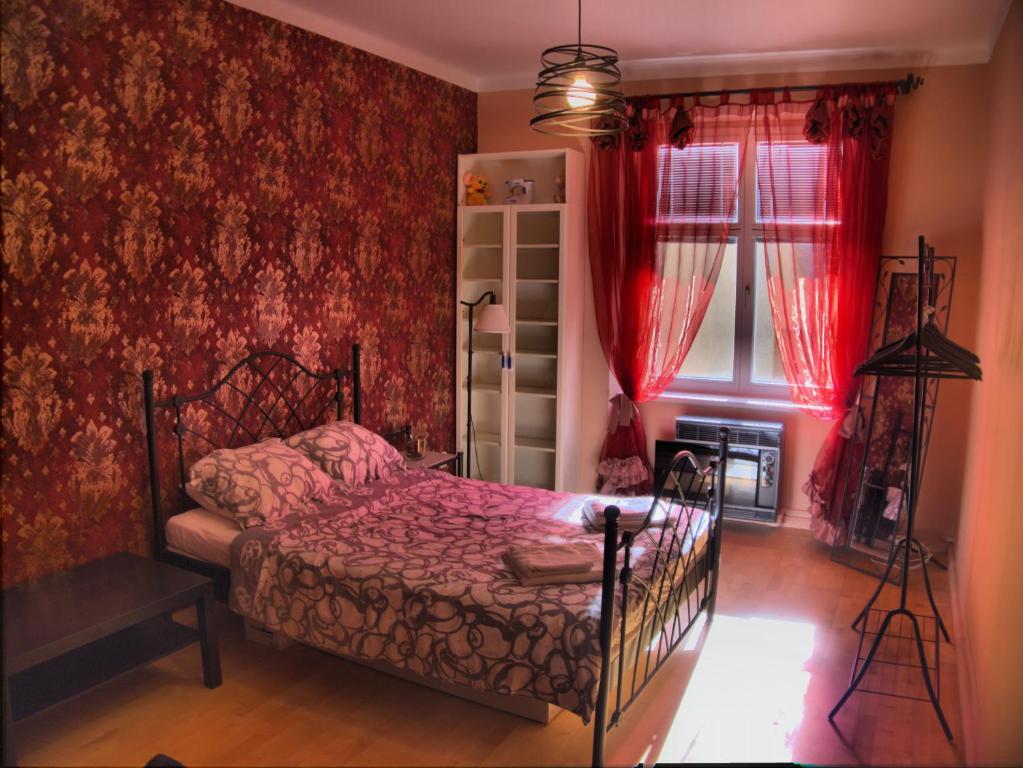 a bedroom with a bed and red wallpaper at Stela's Apartments - Vysehrad in Prague