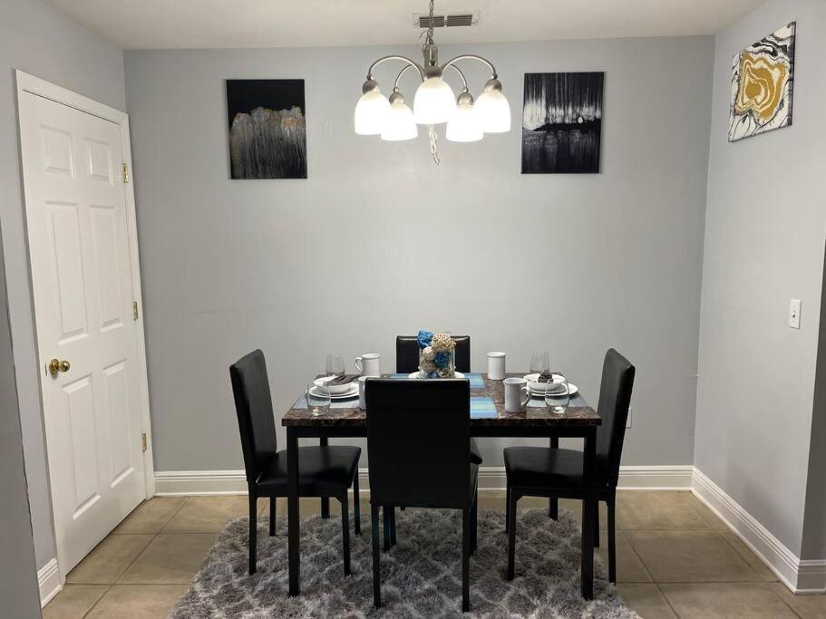 a dining room with a table with black chairs at Cheerful 3-bedrooms with free parking on premises in Tallahassee