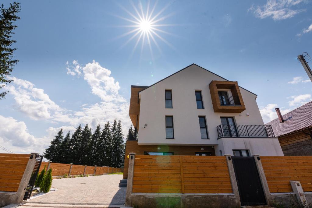 Ein weißes Haus mit der Sonne am Himmel in der Unterkunft Vis de Apuseni in Bălceşti