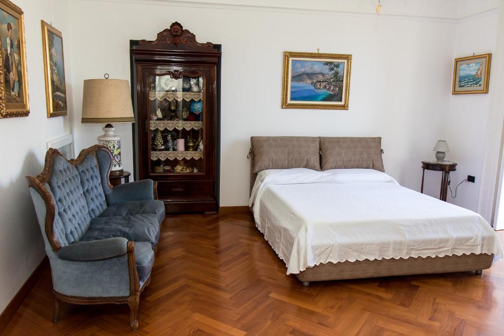 1 dormitorio con 1 cama y 1 silla en Capitano Nino Guest House, en Meta