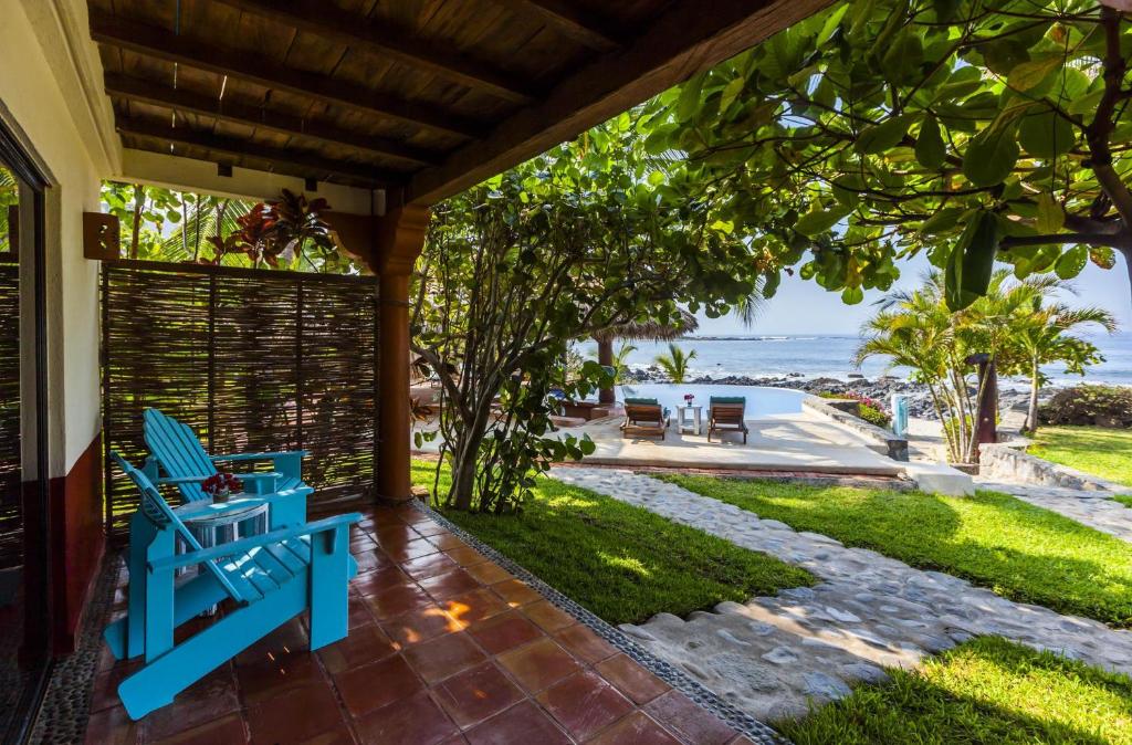 a porch with a blue bench and a view of the ocean at Casa Manzanillo Boutique Hotel in Troncones