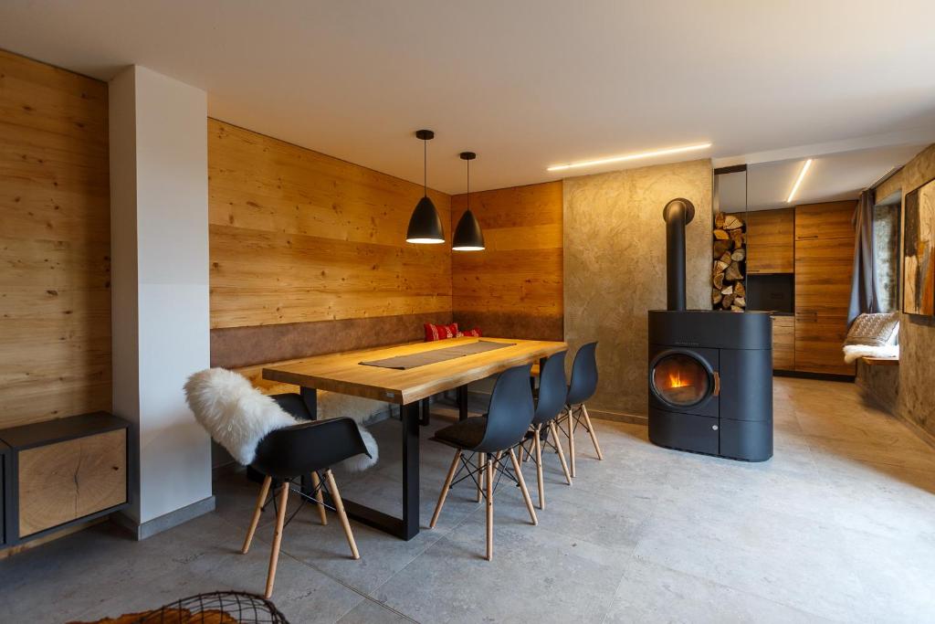 a dining room with a table and chairs and a stove at Chalet Hüttenzauber in Zella-Mehlis