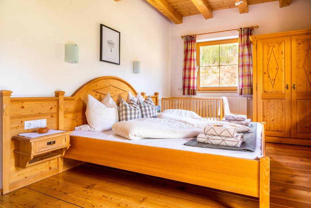 ein Schlafzimmer mit einem großen Holzbett in einem Zimmer in der Unterkunft Öko-Appartements Fallhaus in Forstau