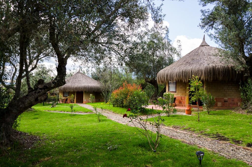 two huts with grass roofs in a yard at Chalets Sol Muisca RNT85322 in Villa de Leyva