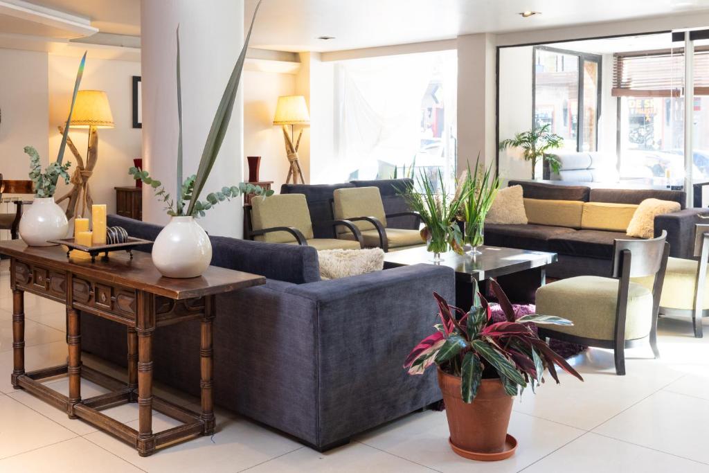 a living room with a blue couch and chairs at Hotel Crans Montana in San Carlos de Bariloche