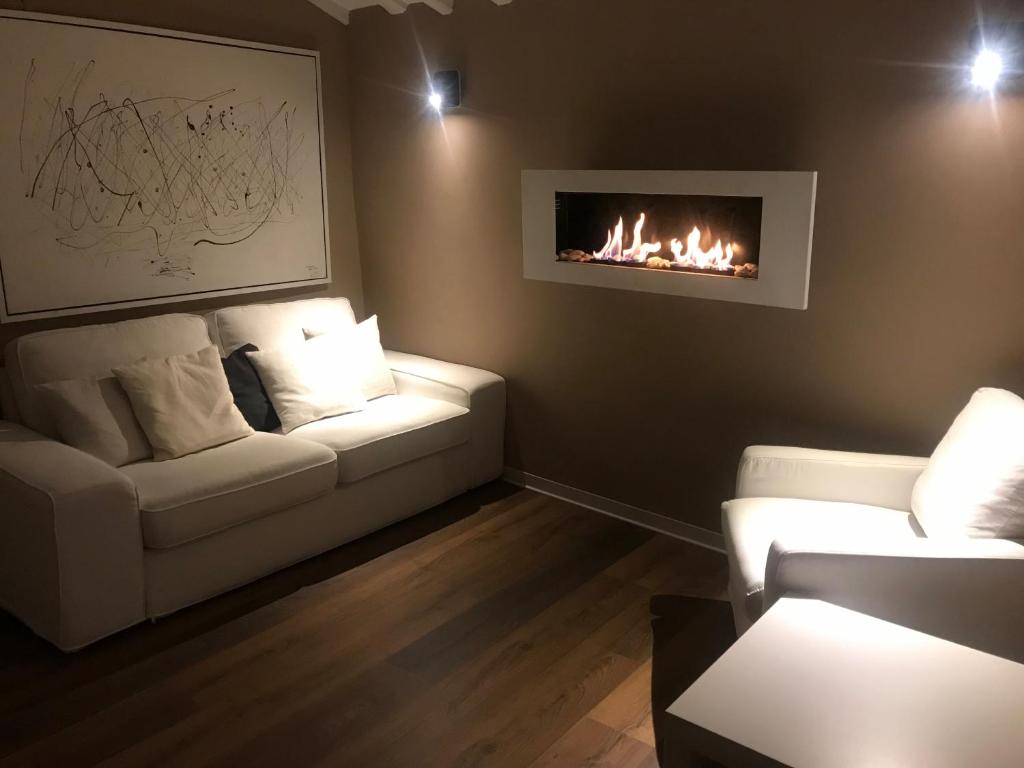 ein Wohnzimmer mit 2 weißen Sofas und einem Kamin in der Unterkunft Casa Relax in Cerreto Laziale