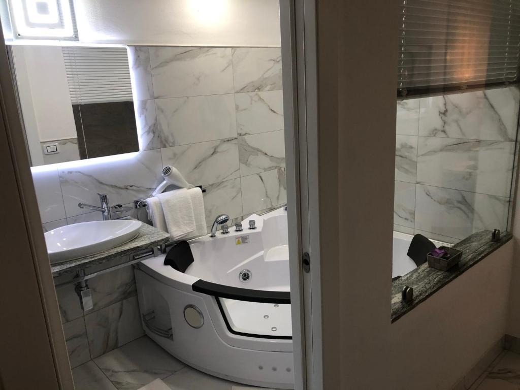 a bathroom with a sink and a bath tub and a sinkessment at Il nido degli angeli in Bologna