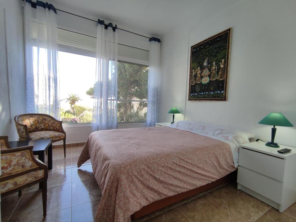 a bedroom with a bed and a large window at PISO PLAYA ALCOSSEBRE in Alcossebre