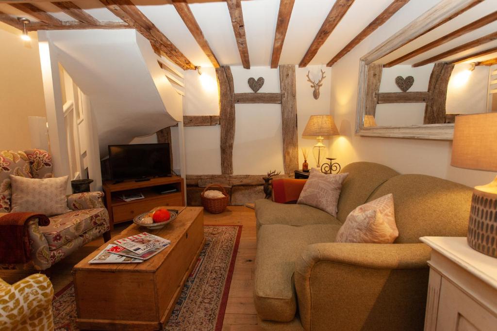 un soggiorno con un divano e un tavolo di Popfosters Barn a Weston Subedge