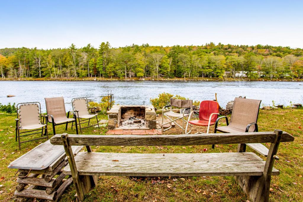 a group of chairs and a picnic table next to a lake at Riverside Bliss in Chestertown