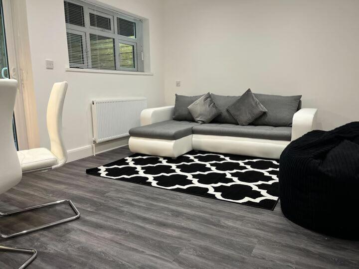 een woonkamer met een bank en een zwart-wit tapijt bij Spacious & Modern CENTRAL 1 bed Apartment with OUTSIDE space in Watford