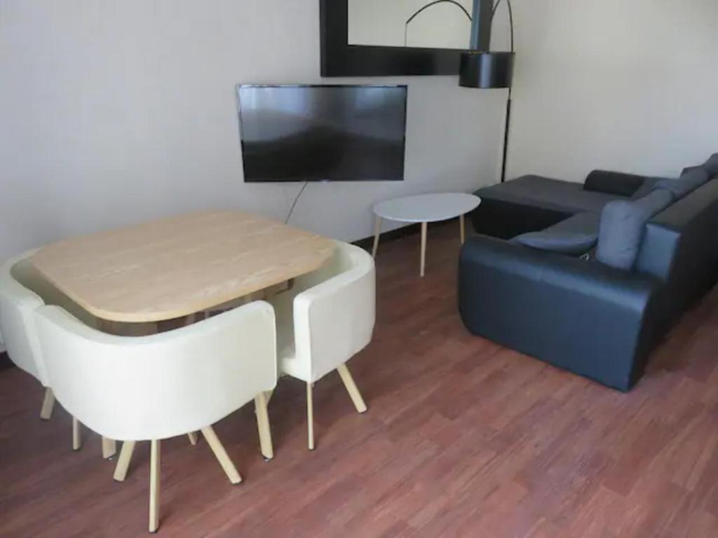 uma sala de estar com um sofá e uma mesa em Appartement T3 em Rennes