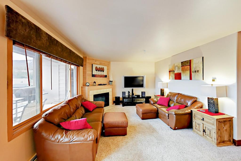 a living room with two leather couches and a fireplace at Watch Hill Condos Unit 614 in Silverthorne