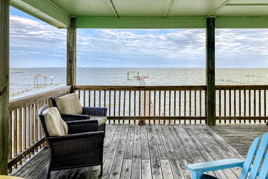 a porch with a couch and chairs on the beach at The Tipsy Trout in Rockport