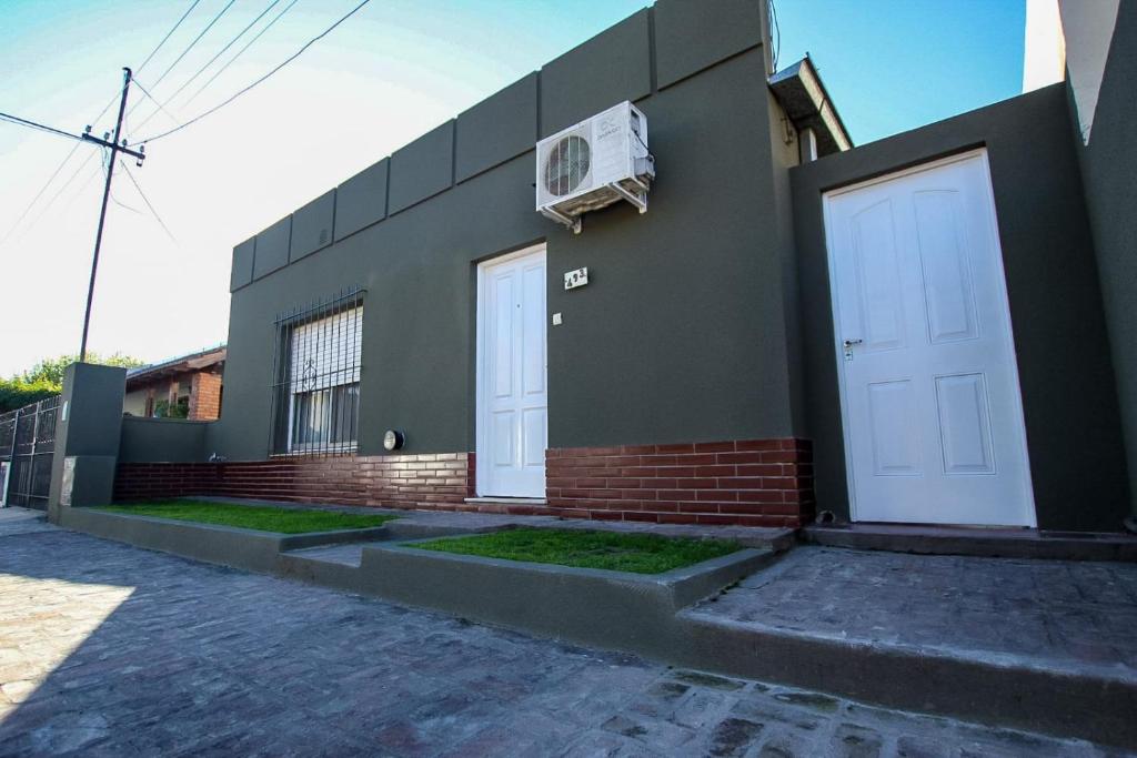a building with two white doors on the side of it at El Descanso in San Antonio de Areco