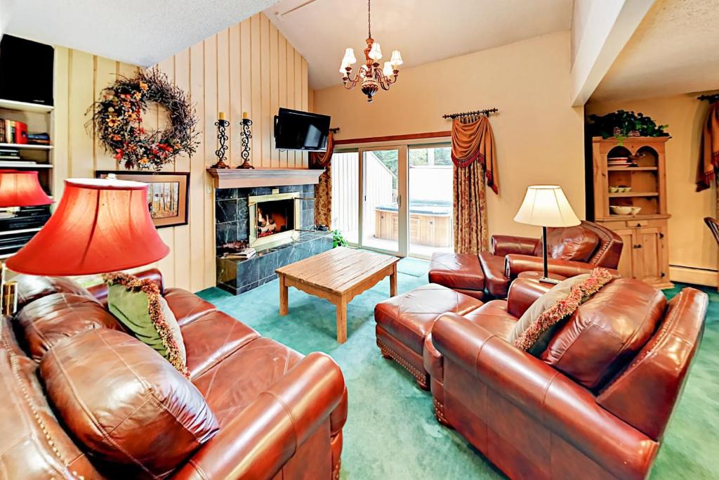uma sala de estar com mobiliário de couro e uma lareira em Creekside Cabins em Vail