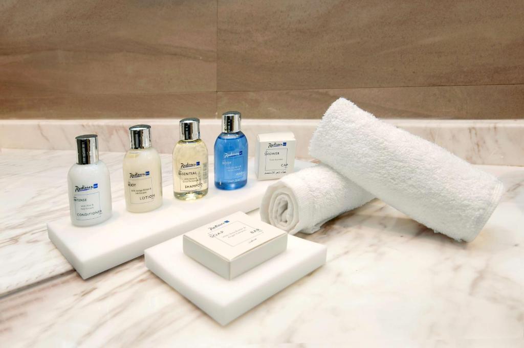 a bathroom with a bunch of bottles on a counter at Radisson Blu Hotel & Resort, Abu Dhabi Corniche in Abu Dhabi
