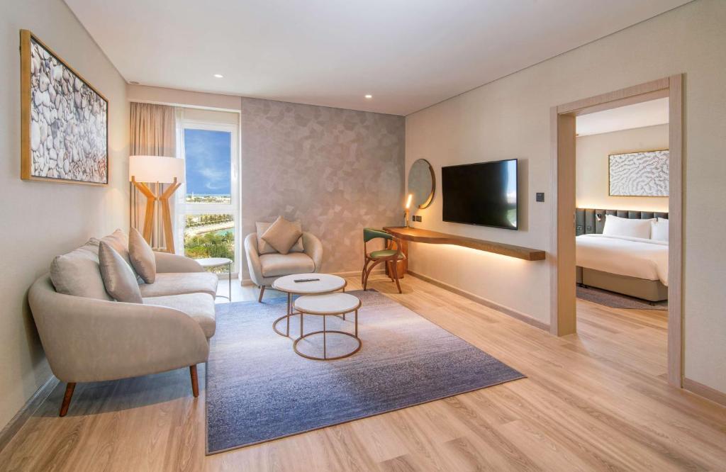 a living room with a couch and a bed at Radisson Blu Hotel & Resort, Abu Dhabi Corniche in Abu Dhabi