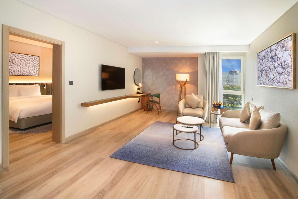 a hotel room with a bed and a living room at Radisson Blu Hotel & Resort, Abu Dhabi Corniche in Abu Dhabi