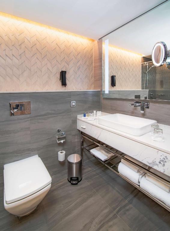 a bathroom with a toilet and a sink at Radisson Blu Hotel & Resort, Abu Dhabi Corniche in Abu Dhabi