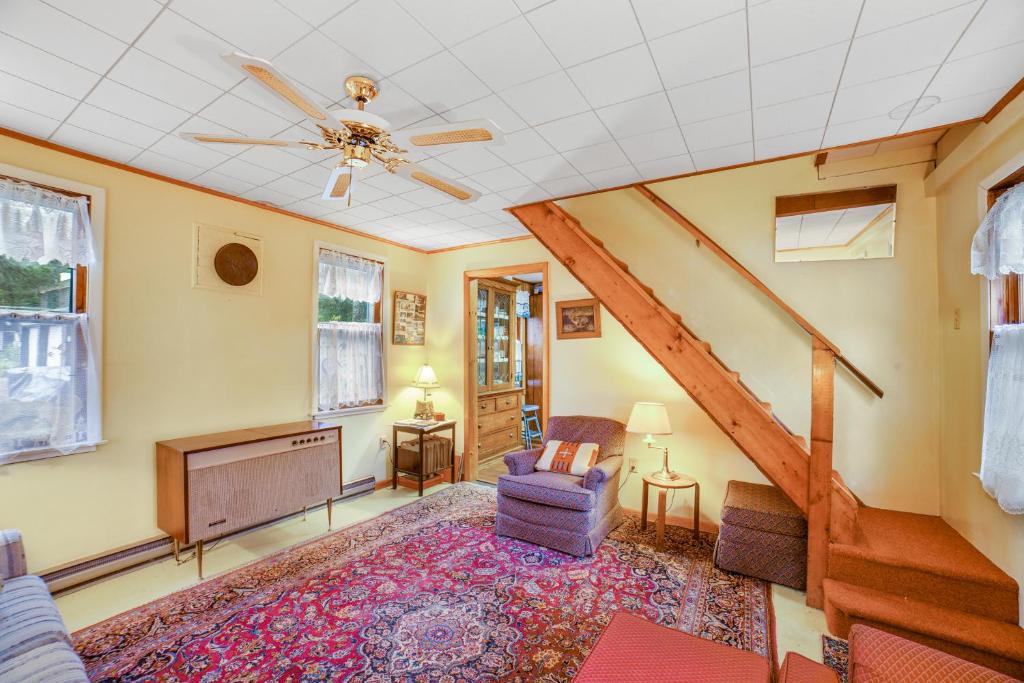 a living room with a ceiling fan and a tv at Hudson Riverside Cottage in Chestertown