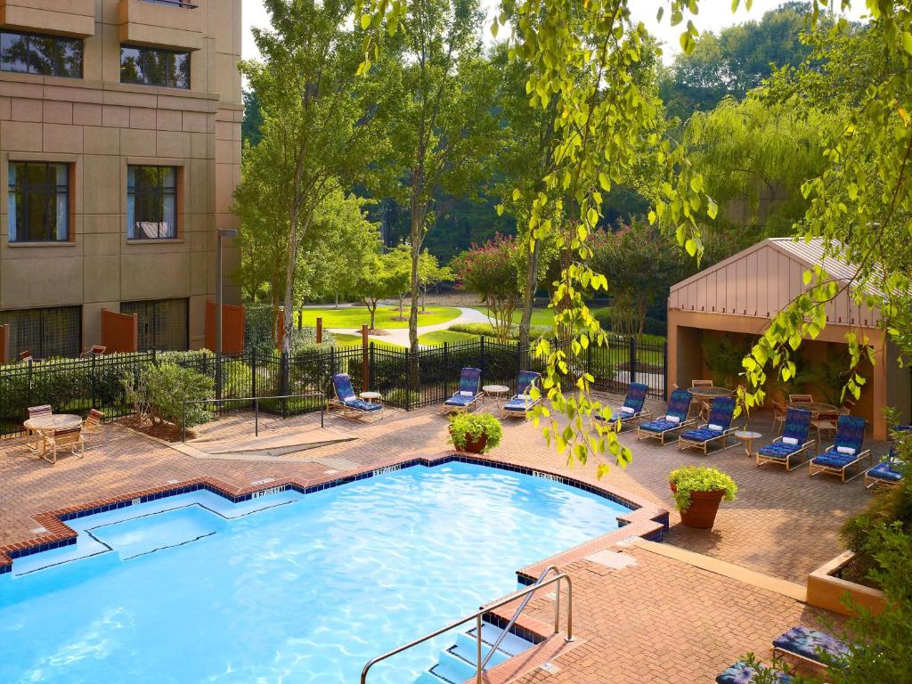 una gran piscina con sillas y un edificio en Sonesta ES Suites Gwinnett Place Atlanta en Duluth