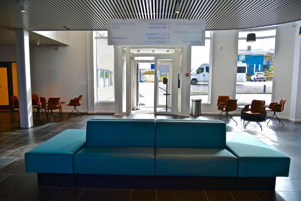 a blue couch in the middle of a lobby at Best Western Plus Hotel Ilulissat in Ilulissat