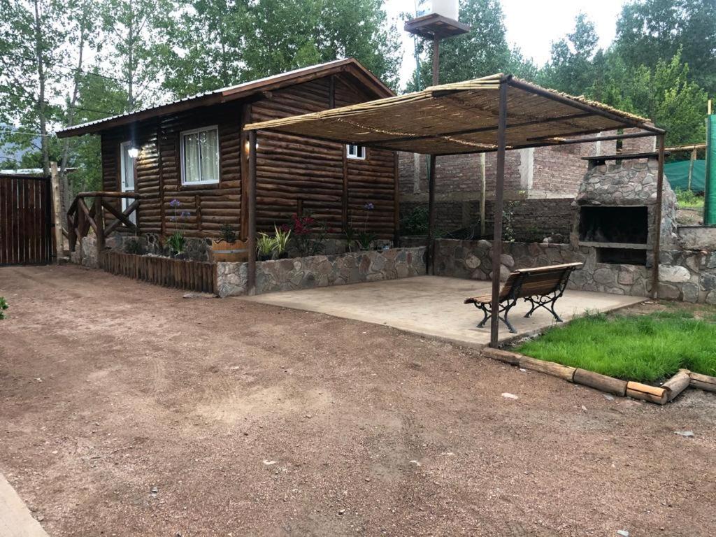 um pavilhão com um banco em frente a uma cabina em Mirador de Montaña em Luján de Cuyo