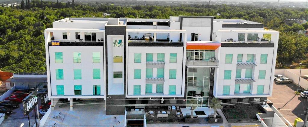 a large white building with green and white windows at Hotel Nuvo in Saltillo