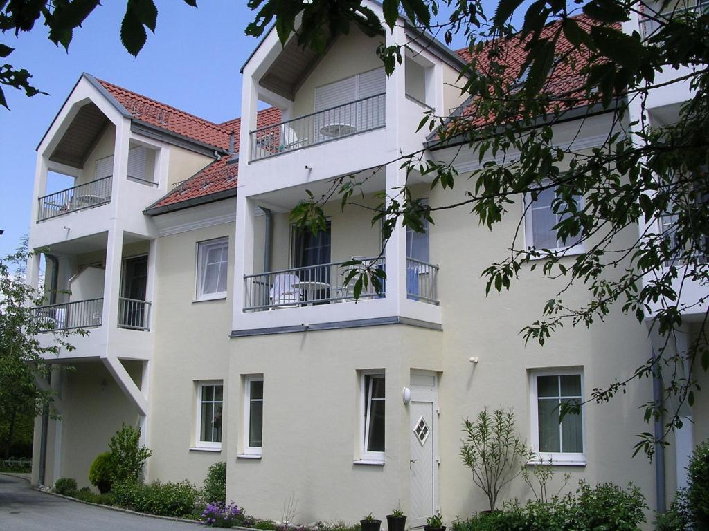 ein weißes Gebäude mit rotem Dach in der Unterkunft Appartementhaus Zum Fuchswirt in Bad Füssing