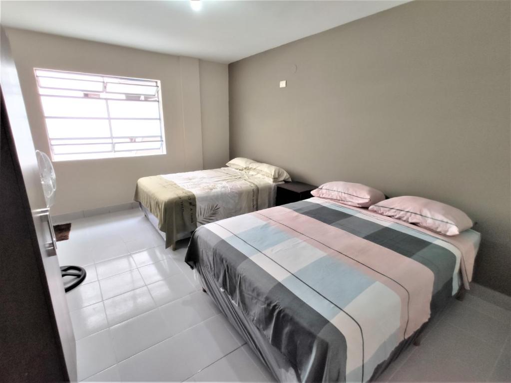a bedroom with two beds and a window at Amaca host, centro histórico, Independencia 249. in Santa Cruz de la Sierra