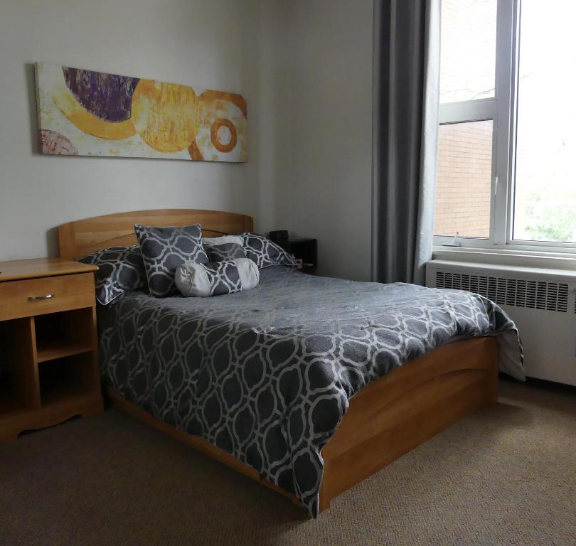 a bedroom with a bed and a desk and a window at Gîte le 812 in Quebec City