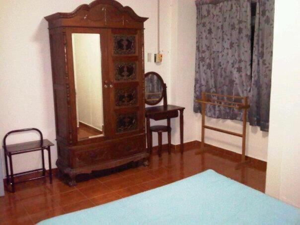 Zimmer mit einem großen Holzschrank und einem Stuhl in der Unterkunft Laguna Condo Resort Port Dickson in Port Dickson