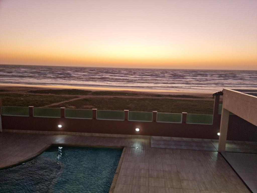 a view of the ocean at sunset from a hotel at Apartamento Vista Mar – Pé na Areia in Cabo Frio