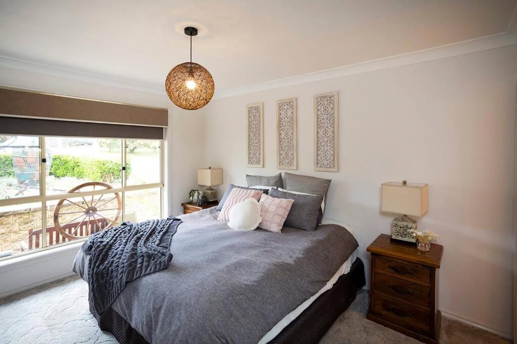 a bedroom with a large bed and a window at Contractor's Heaven and Entertainer in Parkes