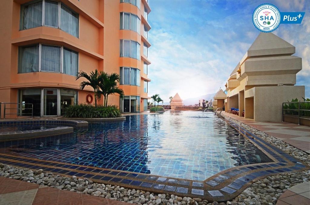 a hotel with a swimming pool in front of a building at Duangtawan Hotel Chiang Mai -SHA Extra Plus in Chiang Mai